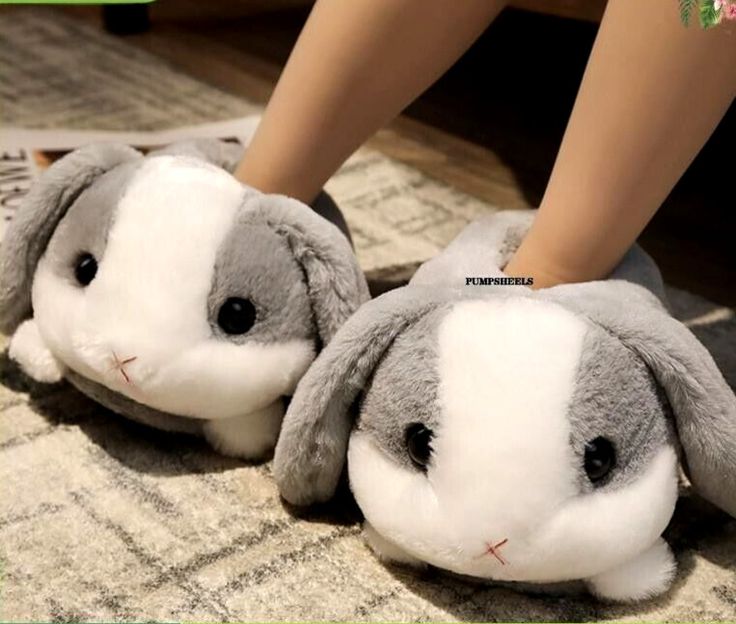 two stuffed animals sitting on top of a carpet next to a person's legs