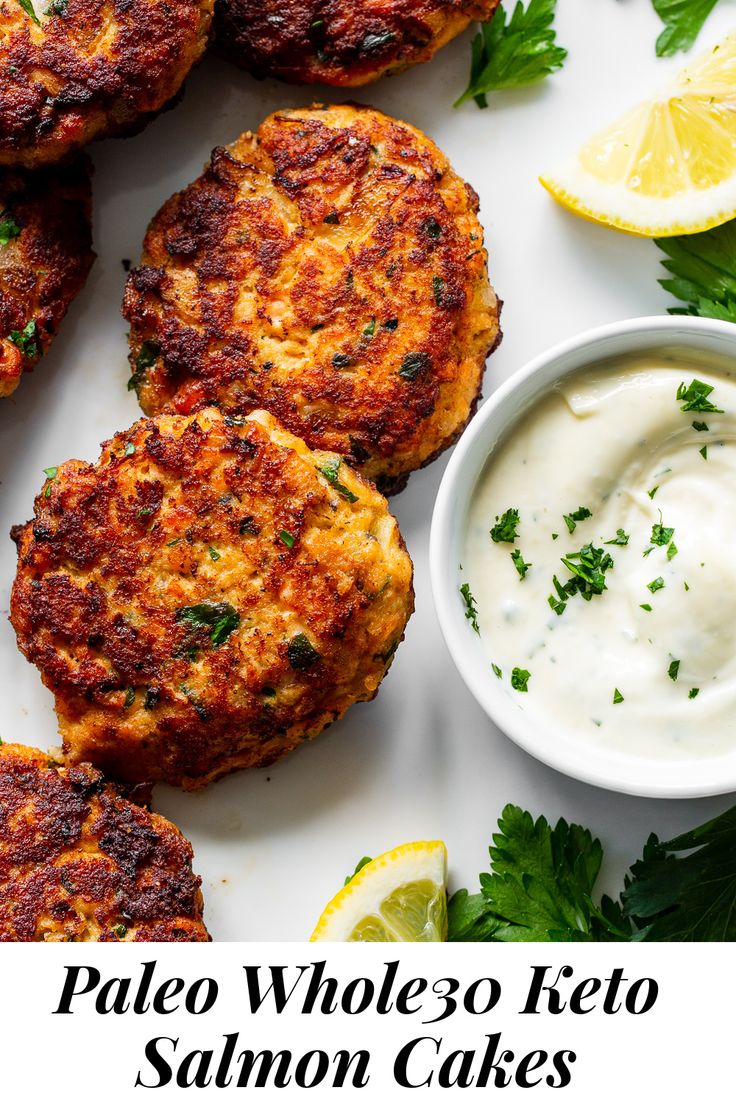 salmon cakes with lemon and parsley on the side, served with yogurt sauce