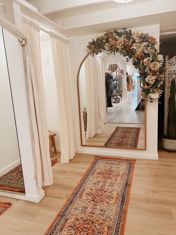 a large mirror sitting on top of a hard wood floor next to a rug and table