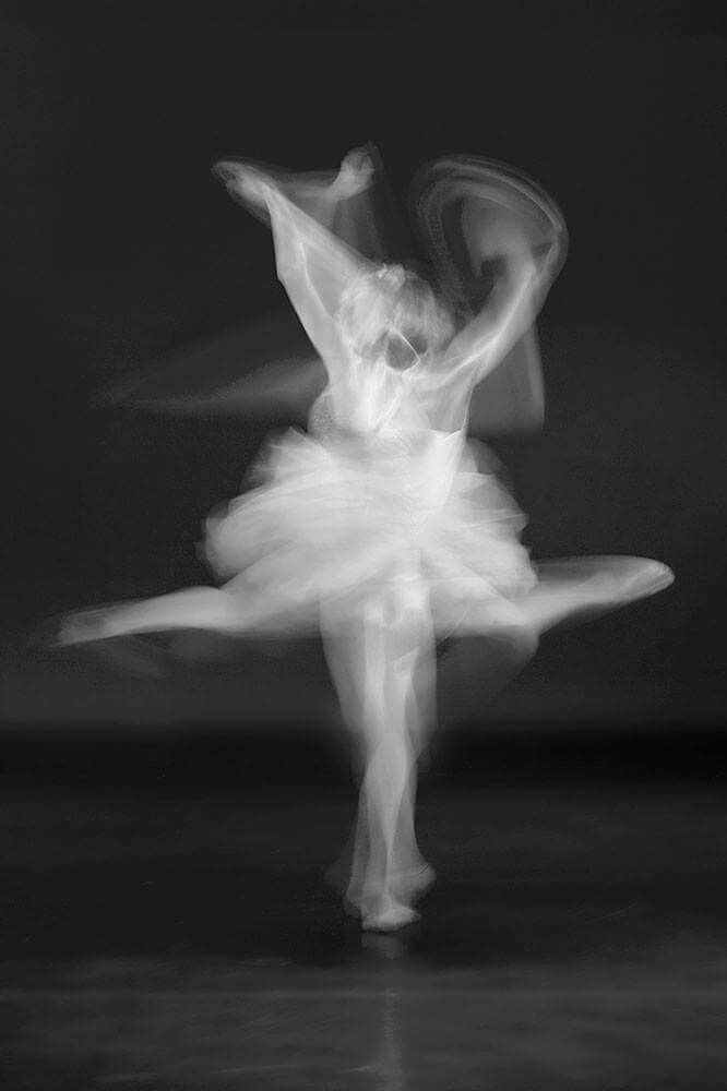 a black and white photo of a ballerina in the middle of an motion blur