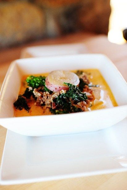 a white bowl filled with food on top of a wooden table