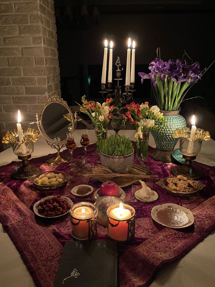 a table topped with plates and candles filled with food