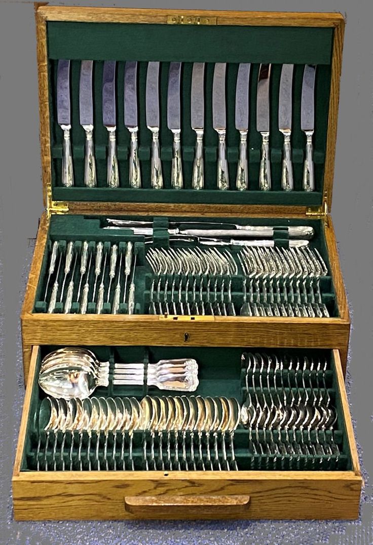 an open wooden box with silverware in it