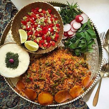 a platter filled with different types of food on top of a table next to utensils