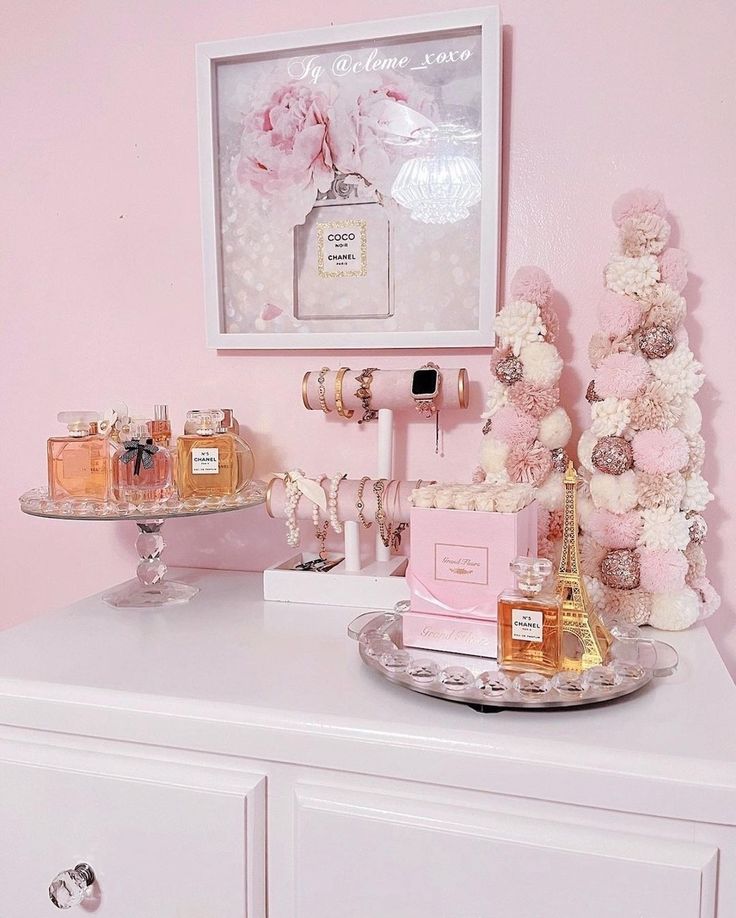 a white dresser topped with lots of pink and white flowers next to a framed picture