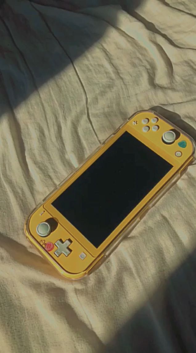 a yellow cell phone laying on top of a bed