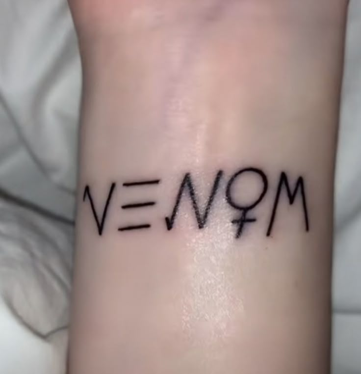 a small wrist tattoo with the word venqm written on it's side