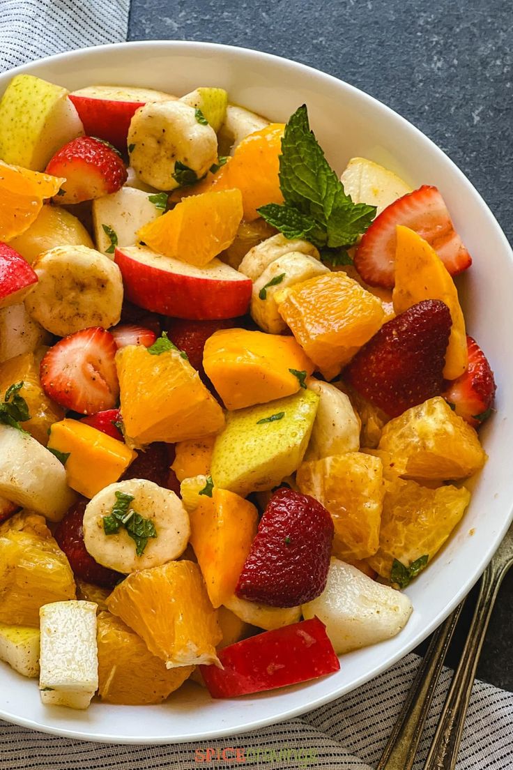 a white bowl filled with fruit on top of a table