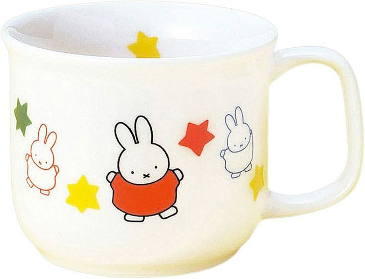 a white coffee cup with cartoon characters on the side and stars in the sky around it