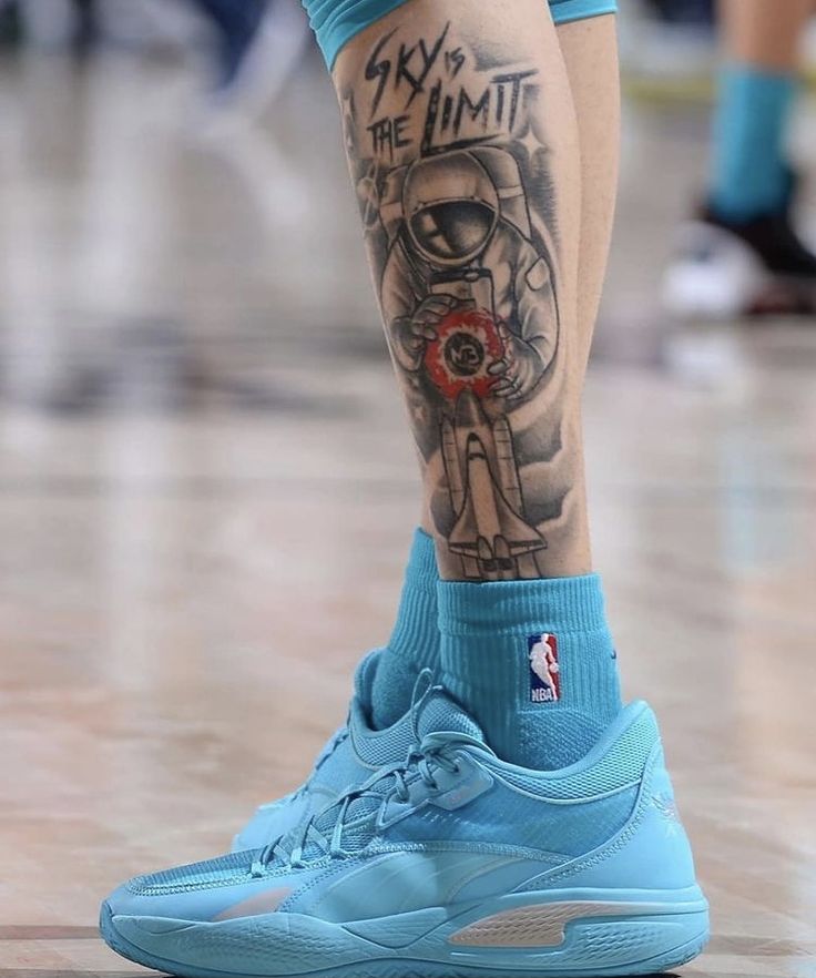 a basketball player's legs with tattoos on them