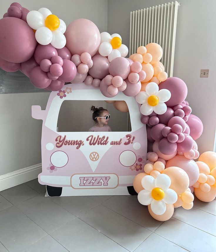 a vw bus decorated with balloons and flowers