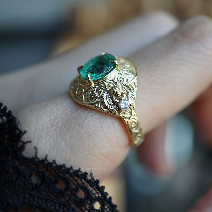 Introducing the "Emerald Scarab Ring" – a captivating blend of ancient Egyptian mystique and timeless elegance. Centered with a lush emerald framed by intricate Islamic patterns inspired by Egypt's architectural wonders, this ring evokes the opulence of ancient Egypt. Flanked by scarabs symbolizing rebirth, each holds a radiant diamond, echoing the sun's eternal sparkle on the Nile's waters. All orders come in our Tippy Taste ring box. This ring is handmade and designed in NYC. 14K or 18K solid gold Natural oval emerald, 8*6mm, approx. 1.20ct Natural round diamonds. SI clarity, GH color, 0.06ct total carat weight 3mm ring band ** Tippy Taste Heirloom Collection is made to order. Please allow 3-4 week turnaround time. Shipping:Domestic: Free shippingInternational: Free shippingAll orders ar Ancient Wedding Rings, Luxury Gold Emerald Ring For May Birthstone, Elegant 14k Stamped Emerald Ring, Ceremonial Yellow Gold Emerald Heirloom Ring, Ceremonial Heirloom Yellow Gold Emerald Ring, Exquisite Yellow Gold Emerald Ring, Yellow Gold Emerald Ring With Intricate Design, Oval Emerald Ring In Gold, Elegant Gold Emerald Ring