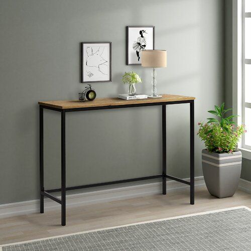 a wooden table sitting next to a potted plant