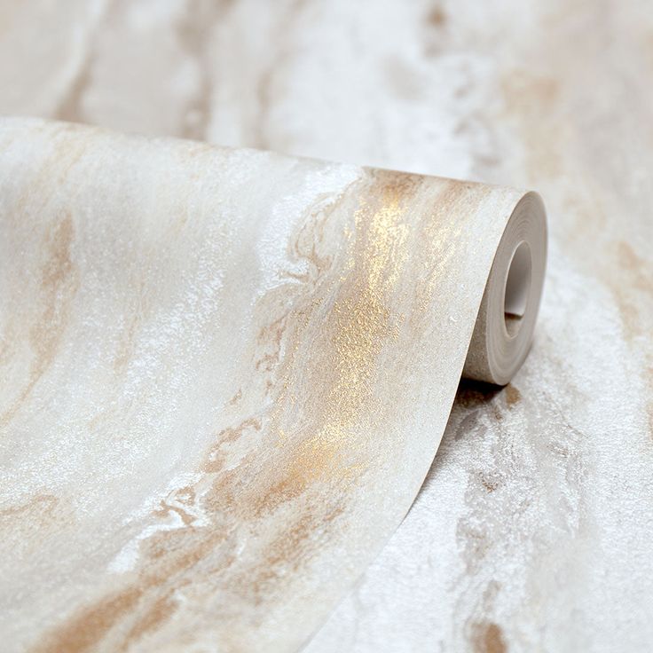 a roll of paper that is on top of a tablecloth covered in white and gold foil