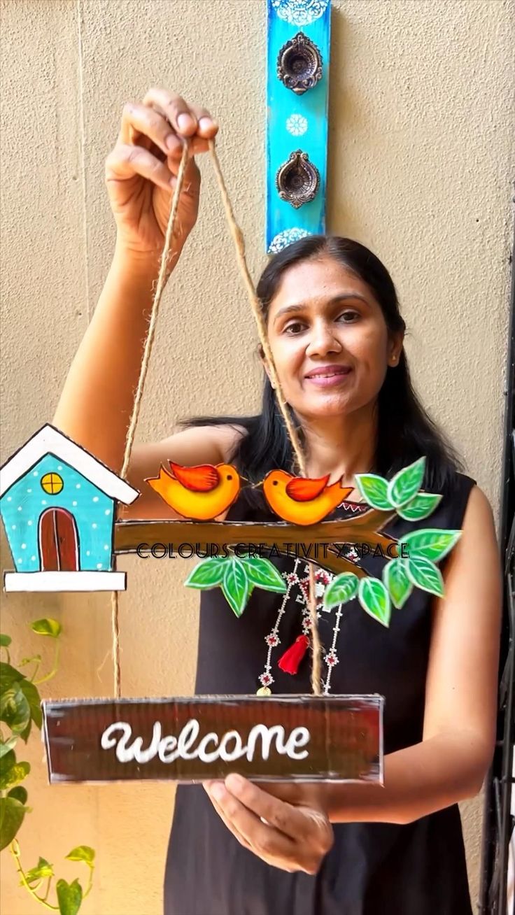 a woman holding up a welcome sign with birds on it