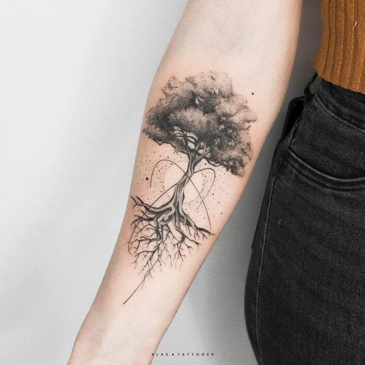 a woman's arm with a tree tattoo on it