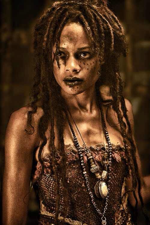 a woman with dreadlocks standing in front of a mirror and looking at the camera