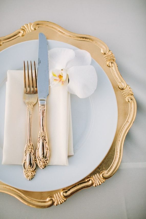 a white plate topped with a fork and knife next to a napkin on top of a table