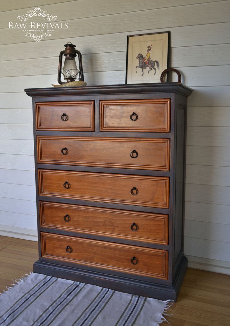 an old dresser is painted black and brown