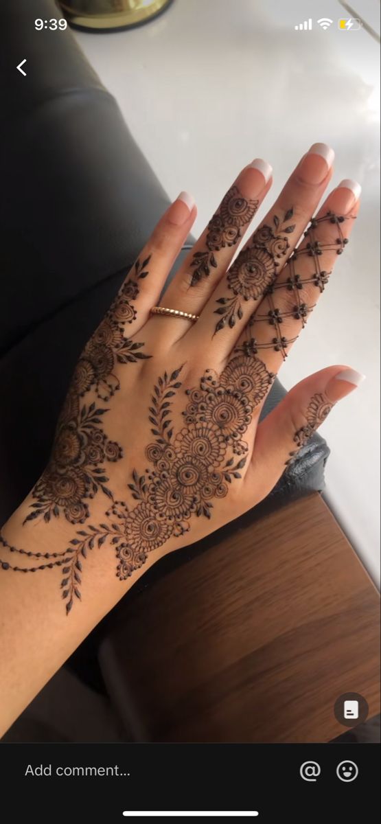 someone's hand with henna tattoos on it