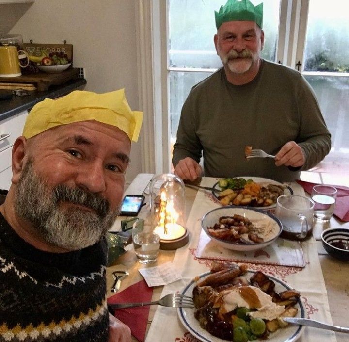 two men sitting at a table with plates of food