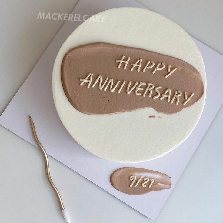 a birthday cake with the words happy anniversary written on it and a pair of scissors next to it