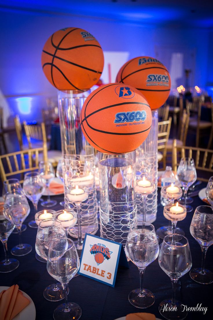 an arrangement of basketballs and candles on a table at a sports themed wedding reception