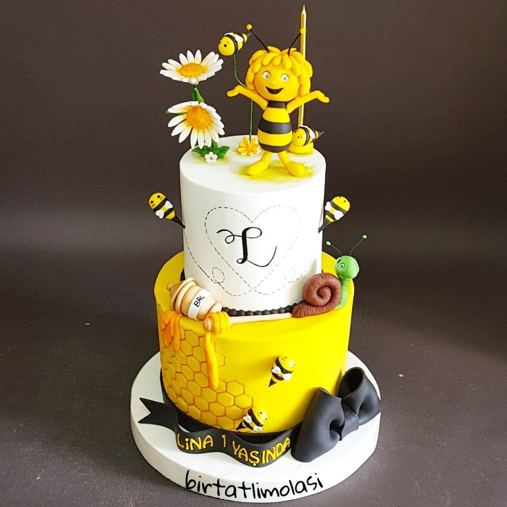 a three tiered cake decorated with bees and flowers