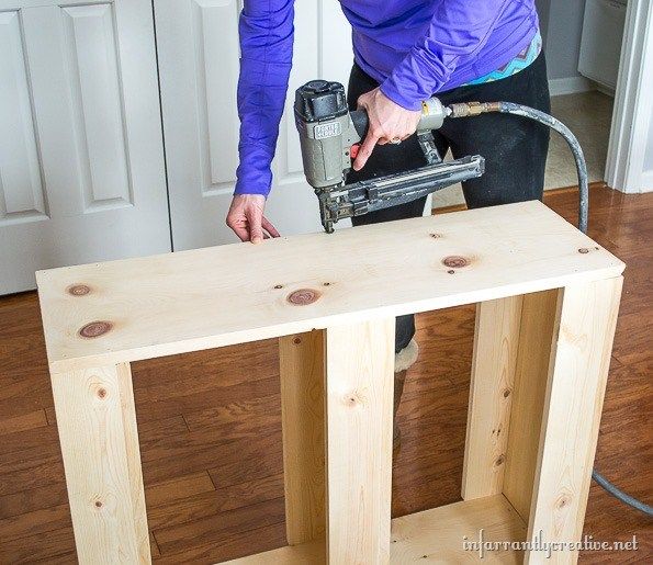 a woman sanding wood with a power drill