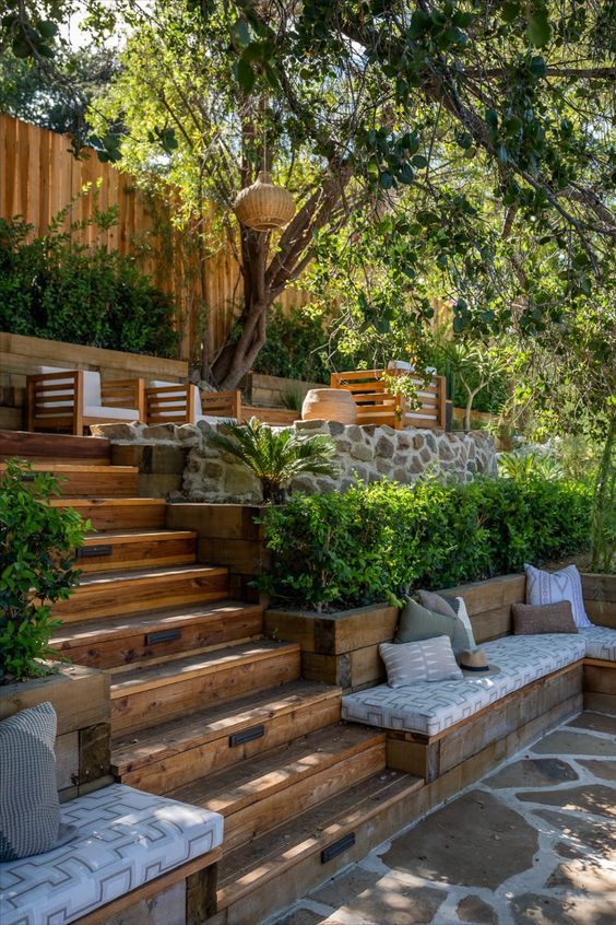 an outdoor seating area with stone steps and trees