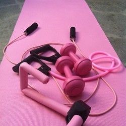 a pink mat with several exercise equipment on it and some cords attached to the top