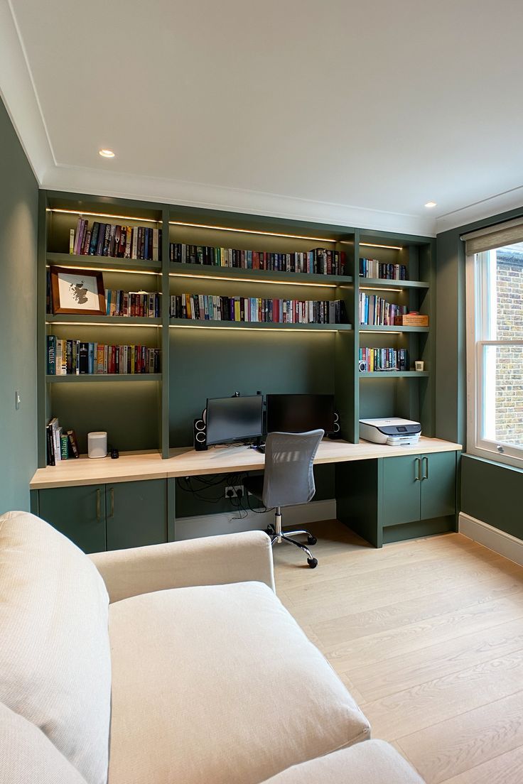 a living room filled with furniture and bookshelves next to a wall mounted book shelf