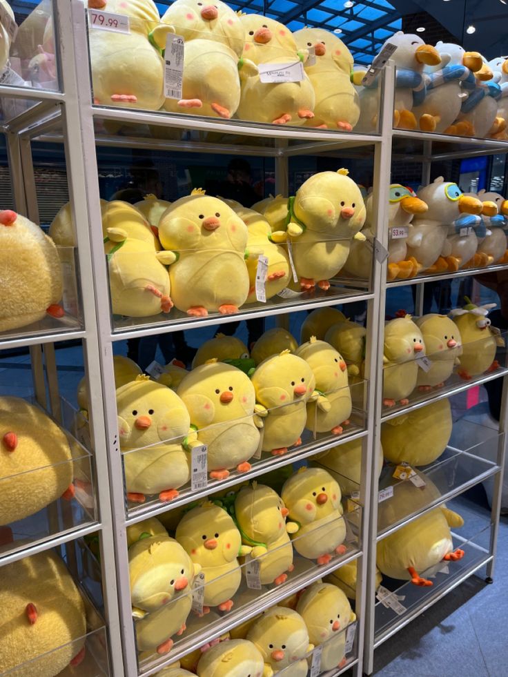 many yellow stuffed animals are on display in a store