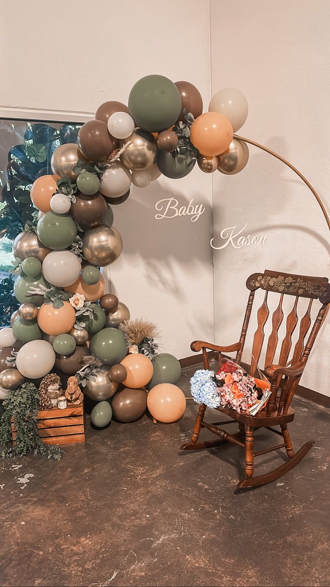 a rocking chair sitting in front of a balloon arch