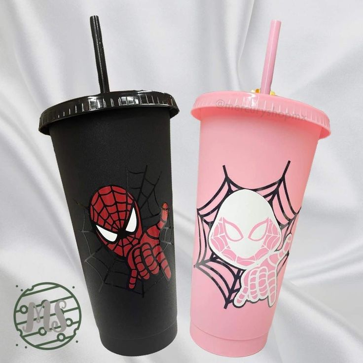 two plastic cups with spider - man and skull designs on them, one has a straw in it