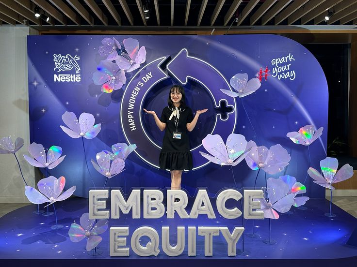 a woman is standing on stage in front of an embrace equity sign