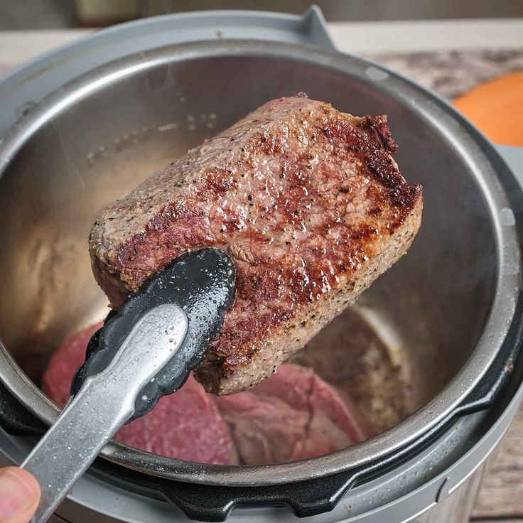 a person is using a meatloaf in a slow cooker to cook steak