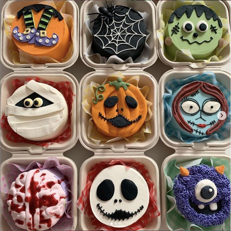 twelve decorated cupcakes in plastic containers with faces and decorations on them for halloween