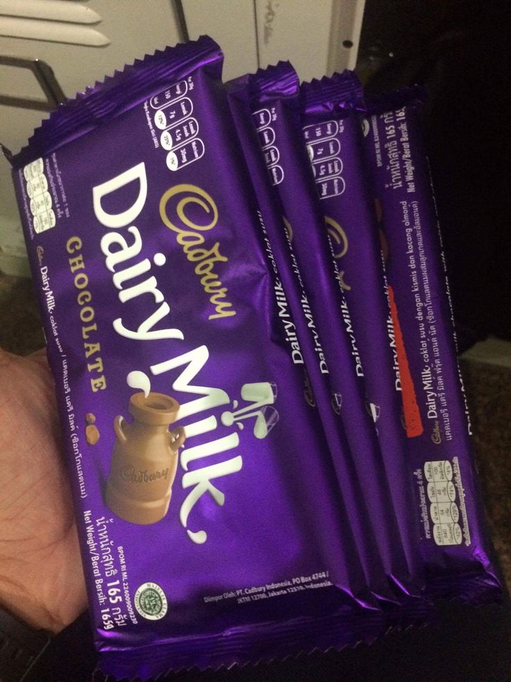 three bags of dairy milk chocolate sitting in someone's hand