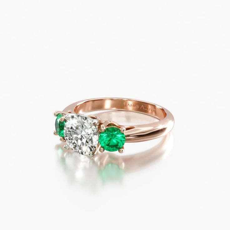 an emerald and diamond engagement ring on a white background, with the top half in yellow gold