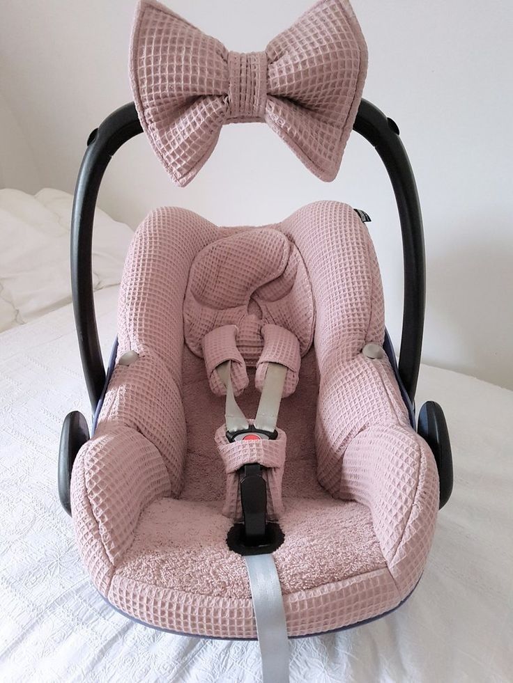 a baby car seat with two bows on it