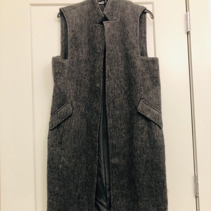 Size Large, Gray Long Waistcoat, Sleeveless, Wool Blend, Fully Lined Interior, Never Worn Practical For Cooler Weather Wool Sleeveless Outerwear For Work, Sleeveless Wool Outerwear For Work, Fall Wool Vest With Pockets, Fall Sleeveless Vest Outerwear, Sleeveless Vest Outerwear For Fall, Sleeveless Vest For Fall, Fitted Sleeveless Outerwear For Fall, Wool Sleeveless Vest For Winter, Sleeveless Wool Vest For Winter