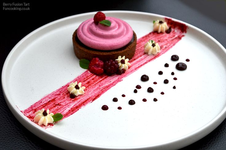 a white plate topped with a dessert covered in pink icing