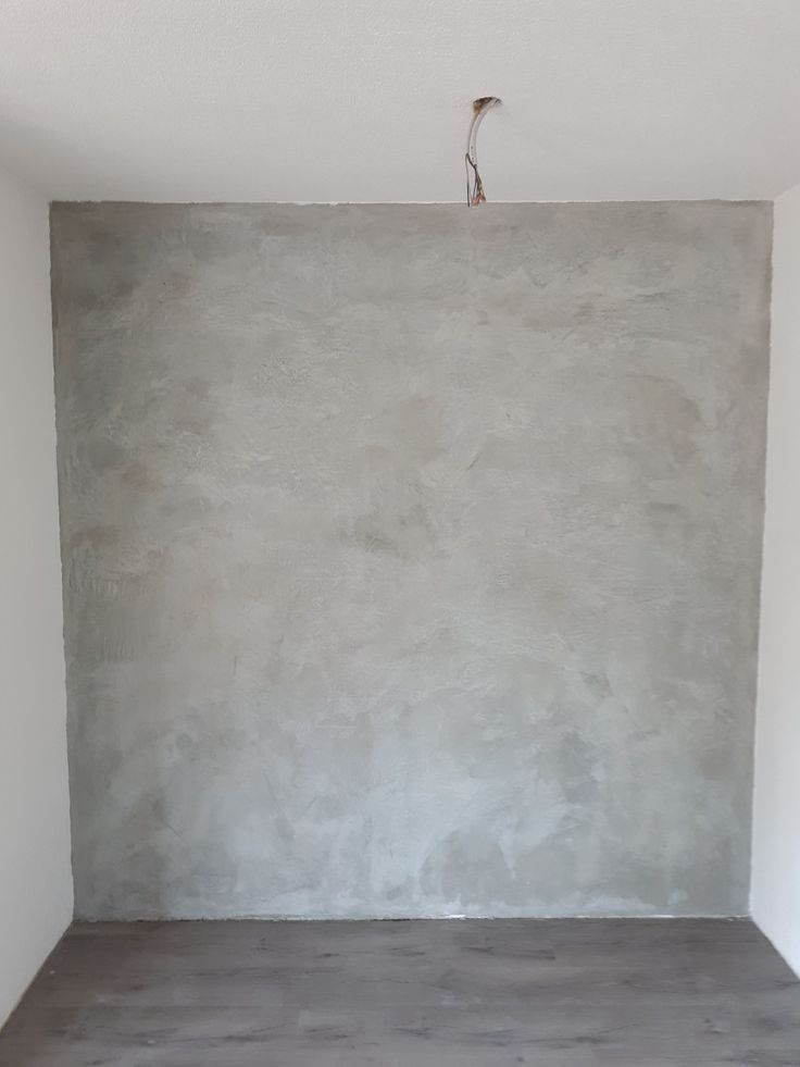 an empty room with concrete walls and flooring in the corner is painted light gray