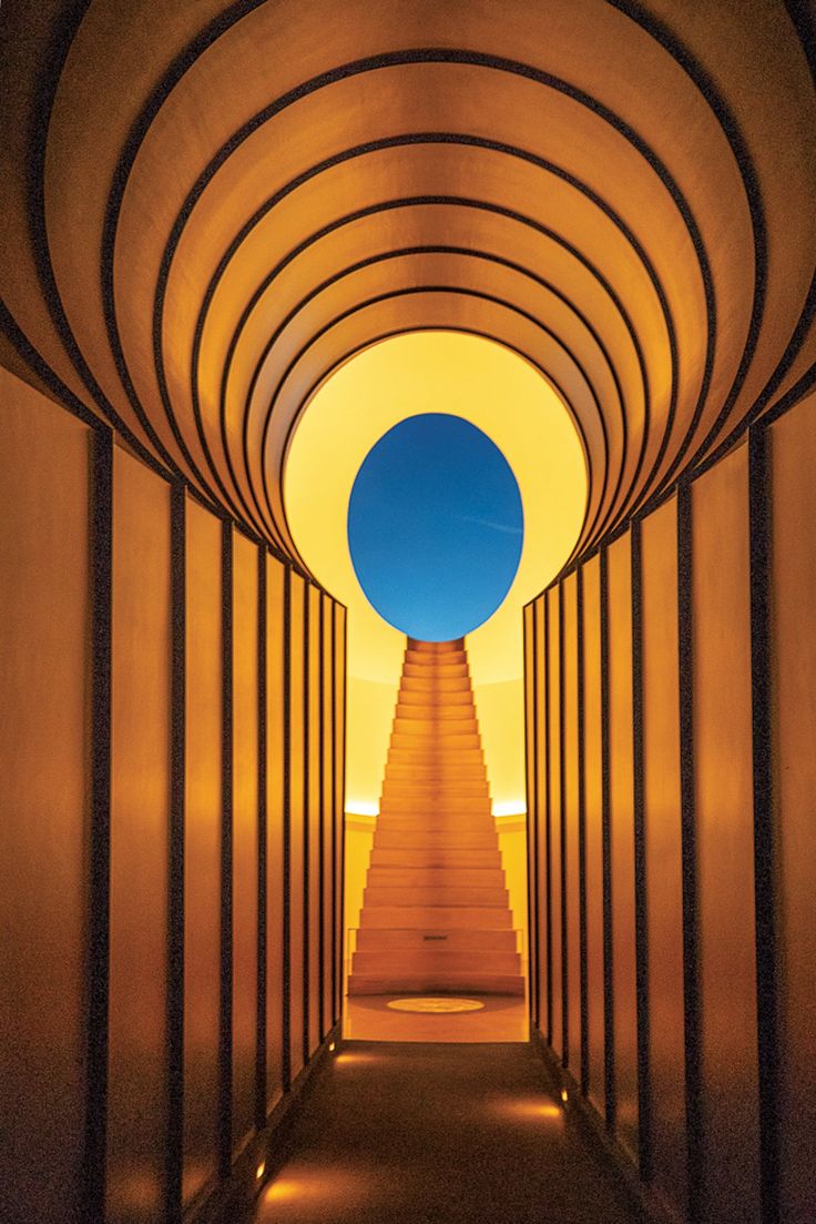 a long tunnel with stairs leading up to the sky