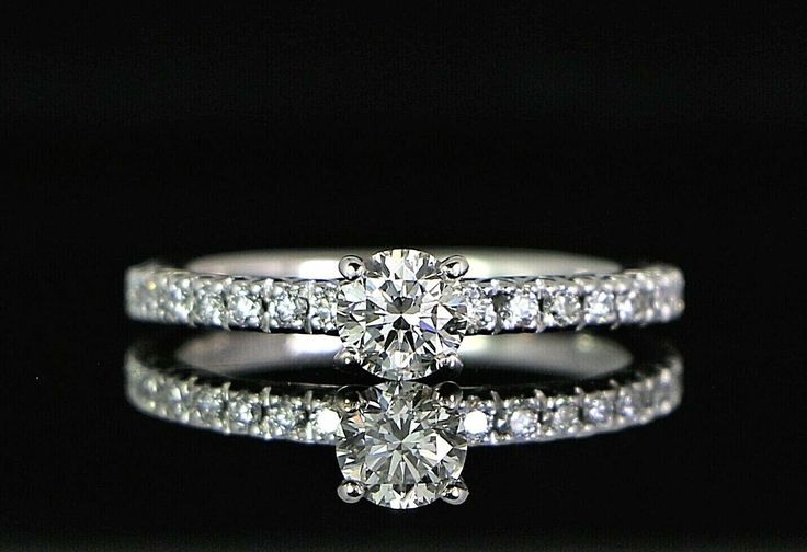 a white gold ring with two diamonds on the side and one diamond in the middle