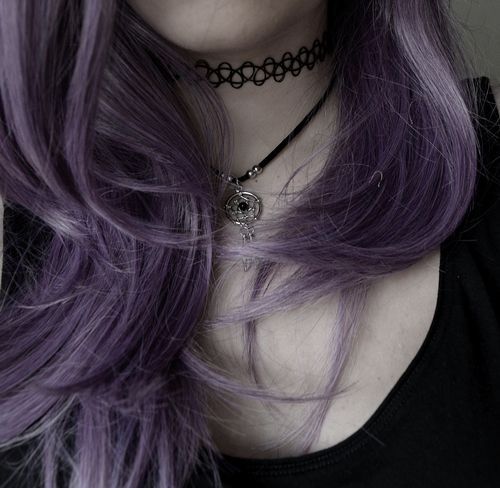 a woman with purple hair wearing a choker