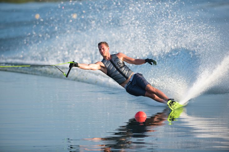 a man riding skis while being pulled by a water skier on a body of water