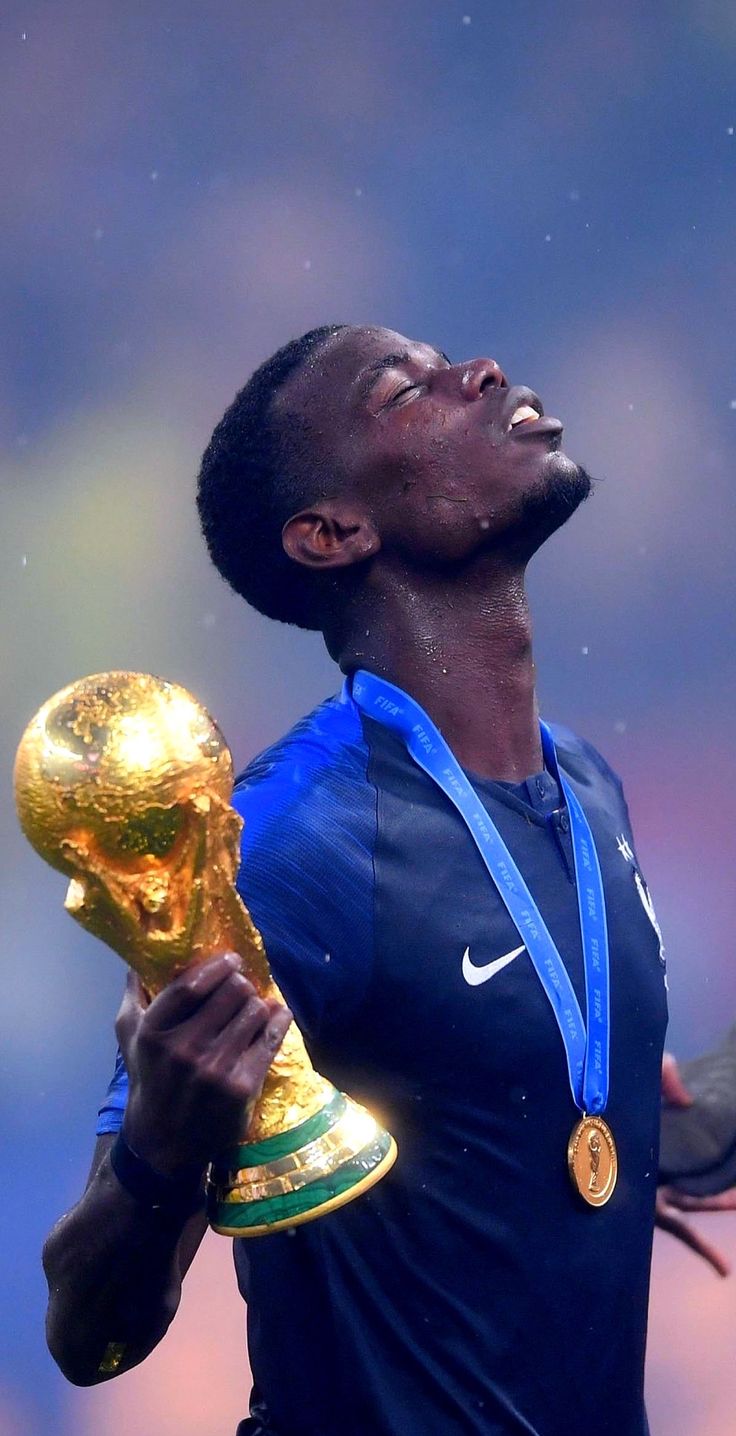 the soccer player is holding his trophy in one hand and looking up into the sky