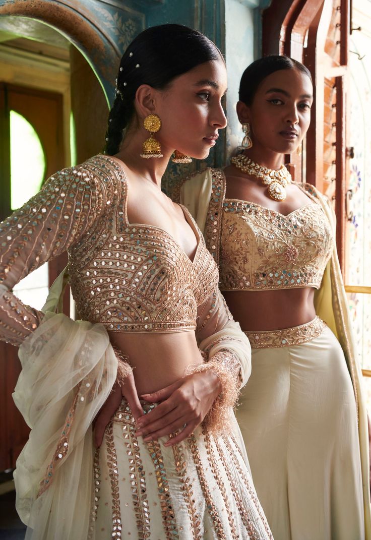 A stunning off-white lehenga with a gold embroidered blouse and skirt bottom.From Bindani’s Rang Mahal collection DELIVERY TIMEPlease allow 8-12 weeks for your outfit to arrive. FABRIC DETAILSHabutai silk Professional cleaning only. Unstitched Blouse Palazzo Set For Wedding Festivals, Wedding Palazzo Set With Unstitched Blouse For Festivals, Wedding Palazzo Set With Unstitched Blouse For Diwali, Diwali Wedding Palazzo Set With Unstitched Blouse, Festive Cream Lehenga With Mirror Work, Cream Bollywood Lehenga For Transitional Season, White Sets With Unstitched Blouse For Party, Elegant Off-white Lehenga For Festive Occasions, Elegant Cream Lehenga For Party